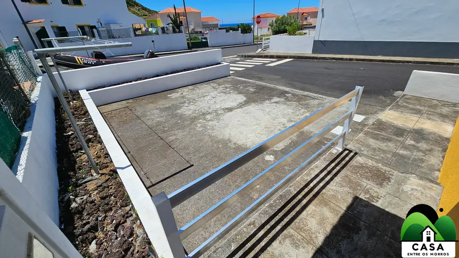 Pátio e estacionamento junto à casa, com vista para o bairro